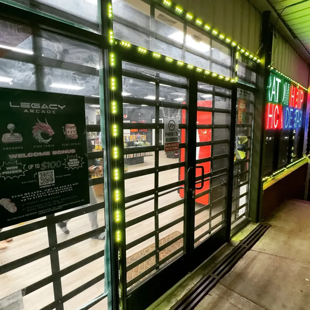 Custom black-framed glass storefront doors with LED accent lighting installed for Legacy Arcade